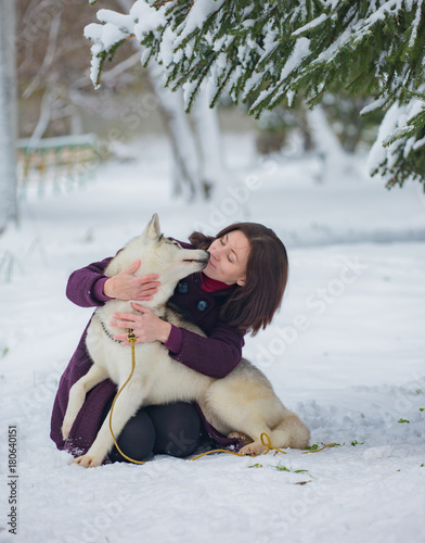 Young woman playing with dog in winter Park