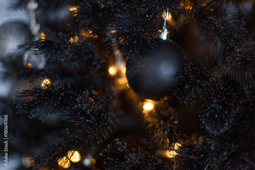 Cuadro en lienzo Christmas dark blurred background with a black Christmas tree, ornaments and bok