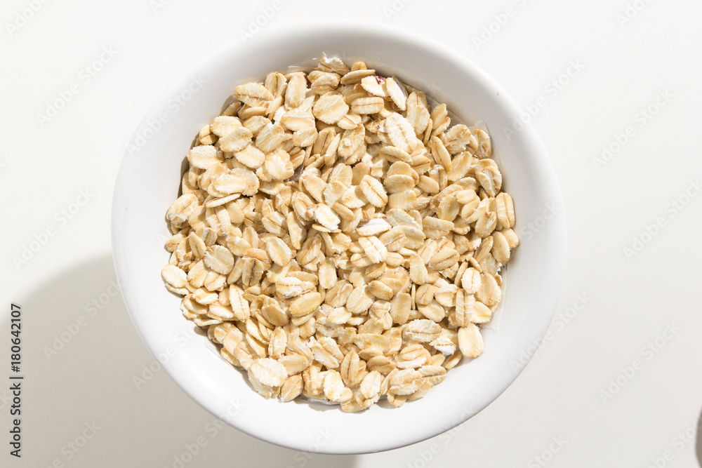 Oat cereal grain. Top view of grains in a bowl. White background Oat cereal grain. Top view of grains in a bowl. White background