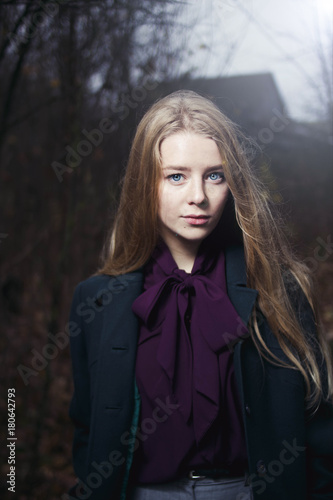 portrait of a blonde at night in the forest. The girl has blue eyes. Vintage Blouse . look at the camera
