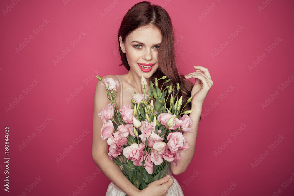the girl on a purple background holds pink flowers