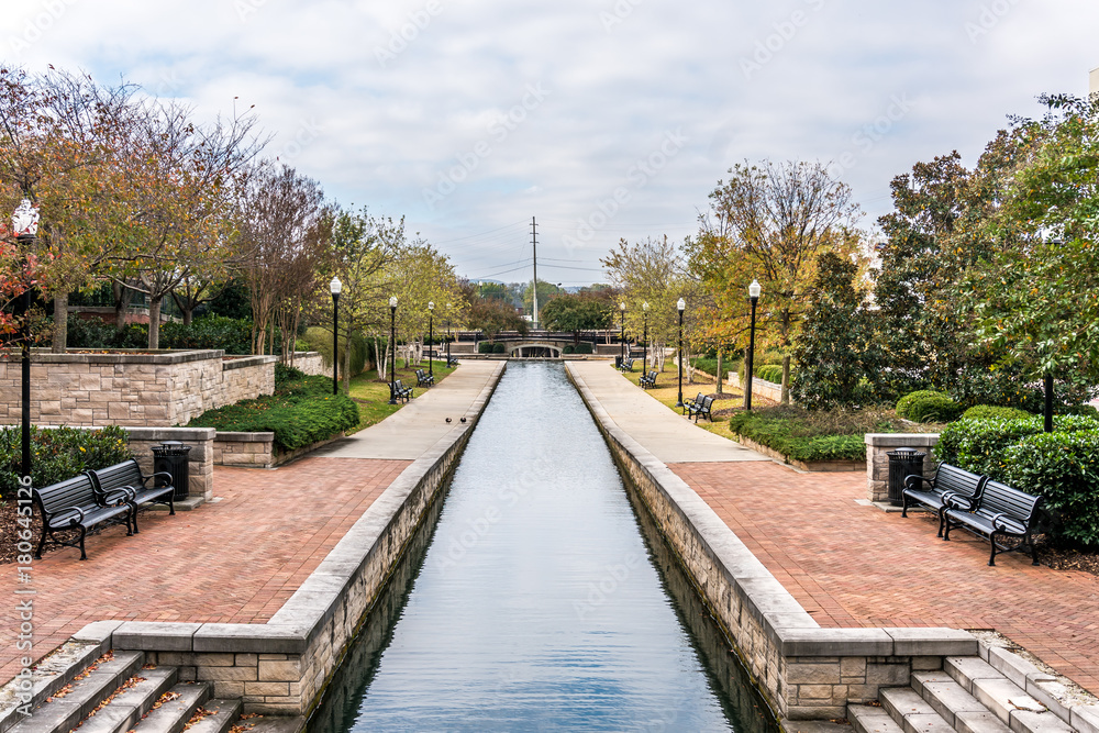 Waterway in park with benches and concrete foreground