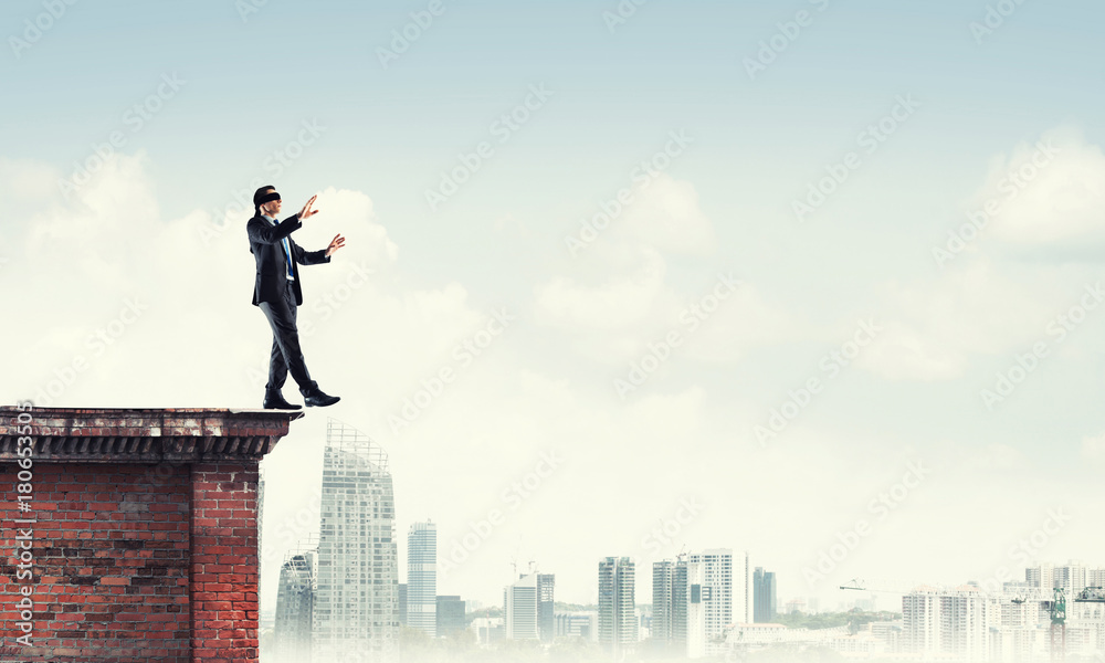 Danger and risk concept with businessman making step from edge Danger and risk concept with businessman making step from edge