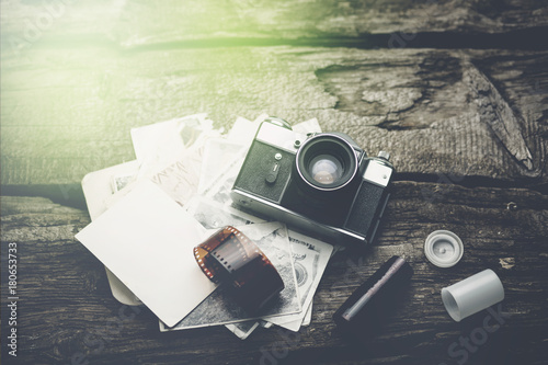 Принти на полотні Old rangefinder camera and black-and-white photos on the old wooden table