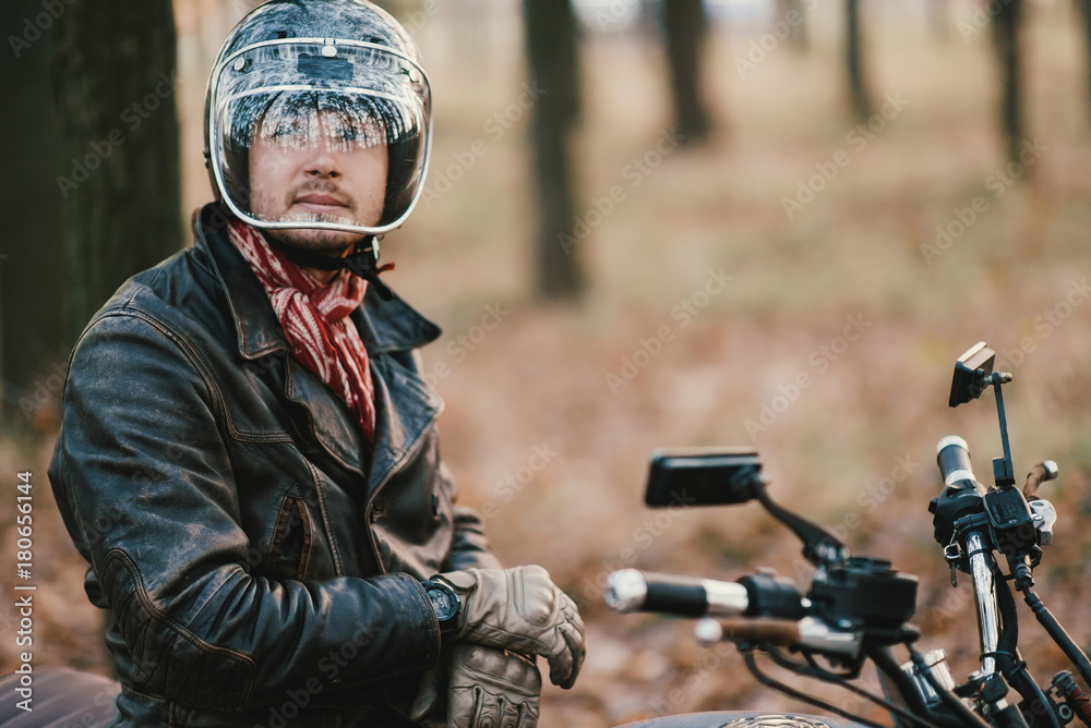 Fototapeta premium Man and old custom cafe-racer Motorcycle on forest 