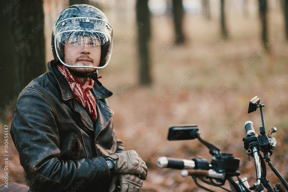 Man and old custom cafe-racer Motorcycle on forest Man and old custom cafe-racer Motorcycle on forest