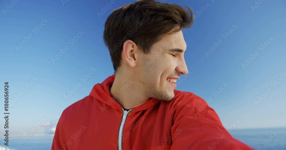 Attractive young man videochatting on the dock. Amazing blue sky and sea view. Nice morning. Outdoors. POV Attractive young man videochatting on the dock. Amazing blue sky and sea view. Nice morning. Outdoors. POV