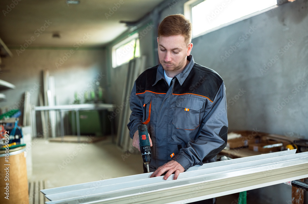 Worker with drilling mashine in workshop Worker with drilling mashine in workshop