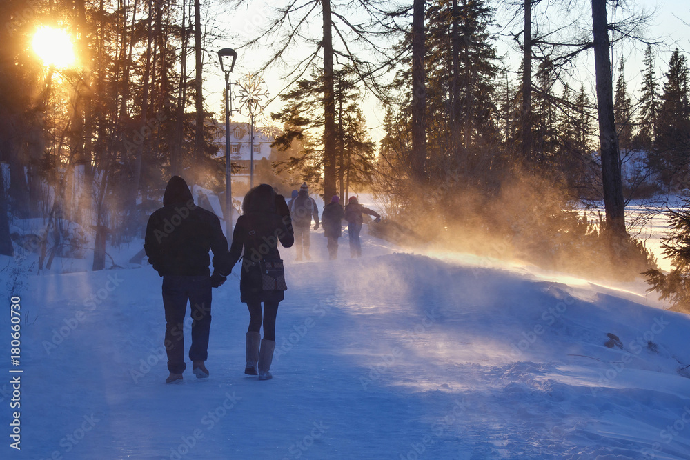 Unknown people walking near of the snowy Stbske Pleso lake. Is a picturesque mountain lake of glacial origin and a top tourist destination in the High Tatras, Slovakia. Unknown people walking near of the snowy Stbske Pleso lake. Is a picturesque mountain lake of glacial origin and a top tourist destination in the High Tatras, Slovakia.
