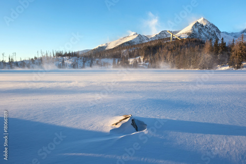 Winter view of the snowy Stbske Pleso lake surrounded by the mountains. Is a picturesque mountain lake of glacial origin and a top tourist destination in the Tatra National Park, Slovakia.