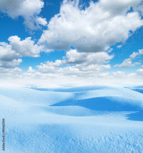 Winter background. Winter landscape with snowdrifts  and blue sky with clouds