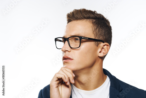 a man in glasses closes his chin and looks away