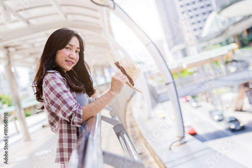 beautiful asian girl travel concept in city with luggabe backpack and camera in casual costume with blur background of city image