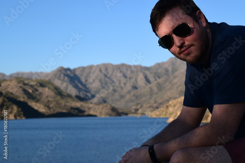 Hombre posando con Lago y montañas de fondo en una tarde de otoño
