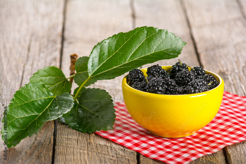 Ripe black mulberry in ceramic bowl Ripe black mulberry in ceramic bowl