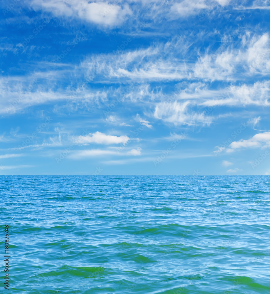 blue sea and sky with clouds over it
