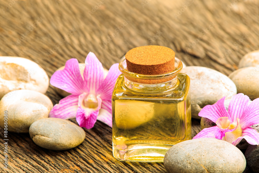 bottle of aroma essential oil or spa with zen stone on wooden table, image for aroma spa alternative therapy medicine and meditation aroma concept. bottle of aroma essential oil or spa with zen stone on wooden table, image for aroma spa alternative therapy medicine and meditation aroma concept.