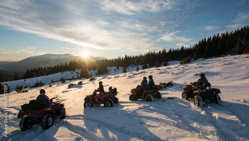 Group of people sitting on four-wheelers ATV bikes, enjoying beautiful sunset in the the mountains in winter