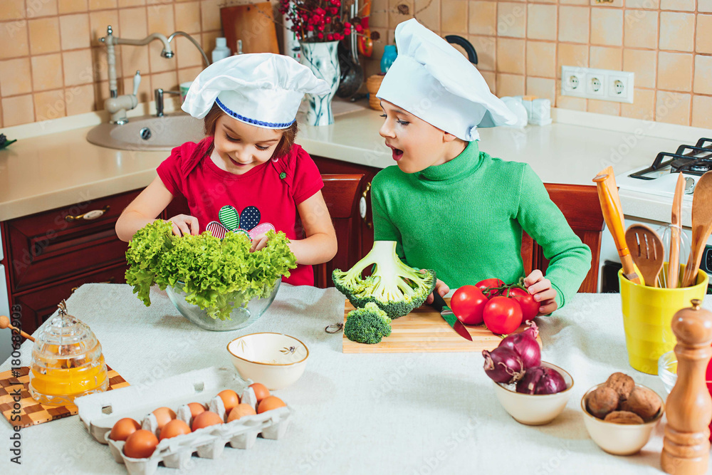 happy family funny kids are preparing the a fresh vegetable salad in the kitchen happy family funny kids are preparing the a fresh vegetable salad in the kitchen
