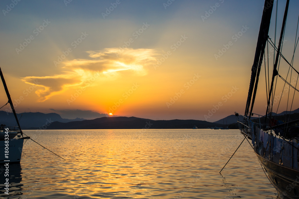 Sailing boats at sunset with Greek islands in the background