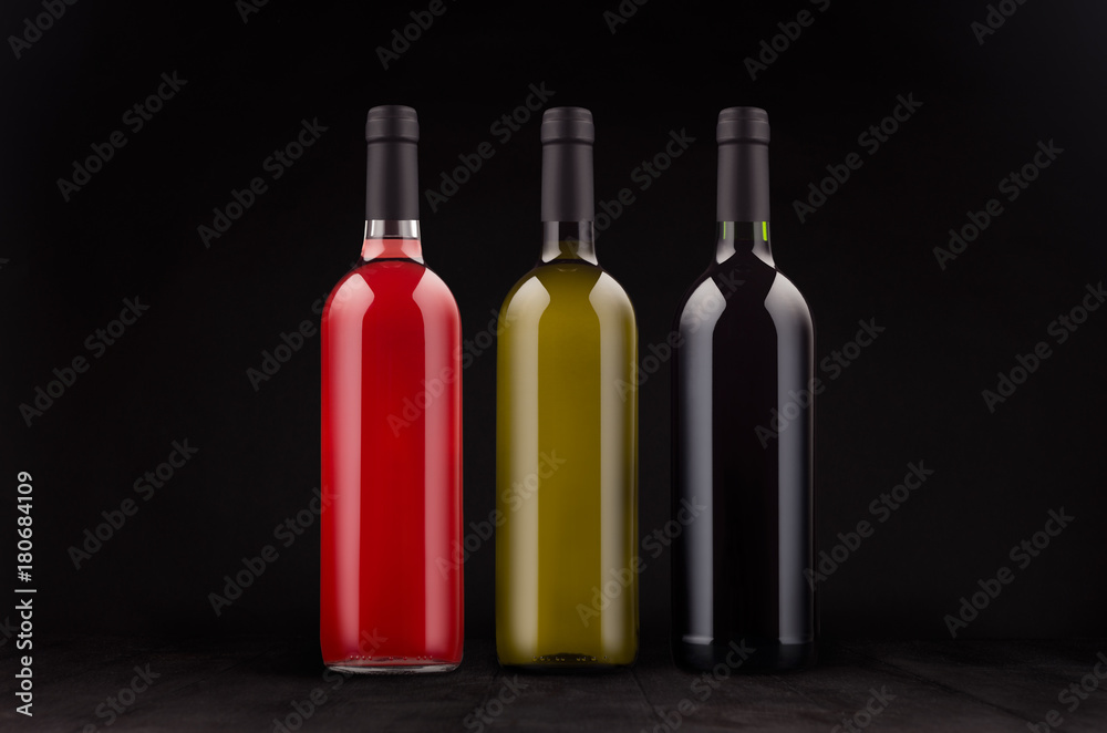 Wine bottles set - red, green, rose - mock up on elegant dark black wooden background. Template for portfolio, advertising, design, branding identity, cover magazine, bar and restaurant menu. Wine bottles set - red, green, rose - mock up on elegant dark black wooden background. Template for portfolio, advertising, design, branding identity, cover magazine, bar and restaurant menu.