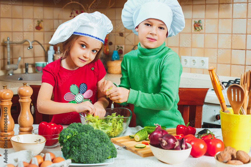 happy family funny kids are preparing the a fresh vegetable salad in the kitchen happy family funny kids are preparing the a fresh vegetable salad in the kitchen