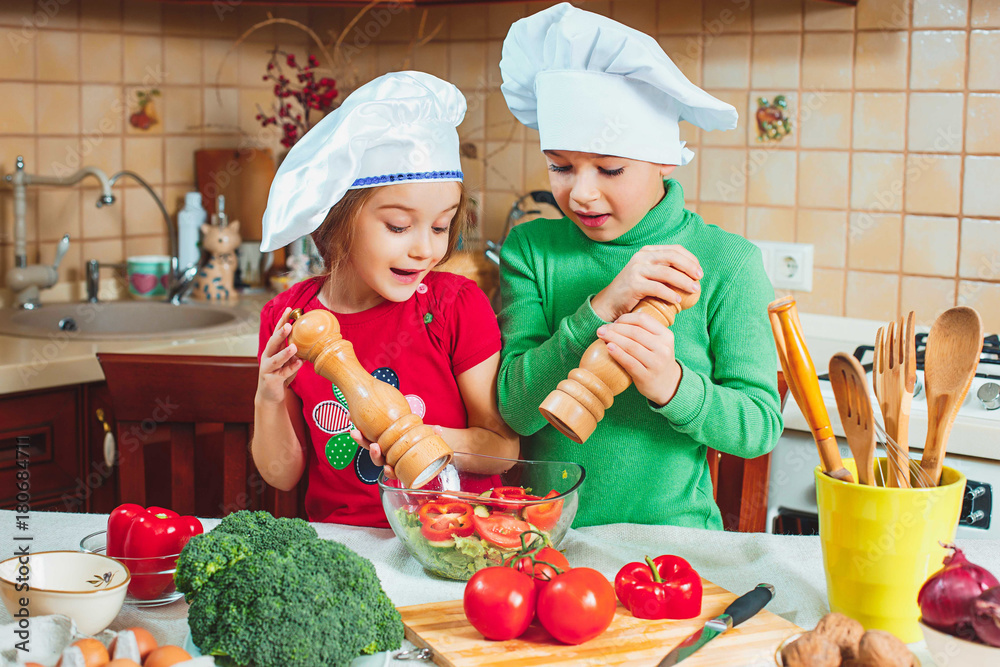 happy family funny kids are preparing the a fresh vegetable salad in the kitchen happy family funny kids are preparing the a fresh vegetable salad in the kitchen