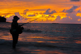 Silhouette of lonely angler in the sunset