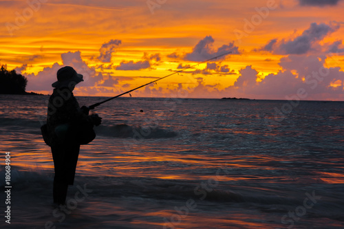 Silhouette of lonely angler in the sunset