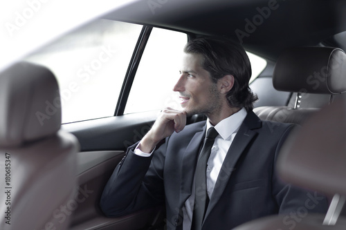 successful man sitting in the back seat of a car © ASDF