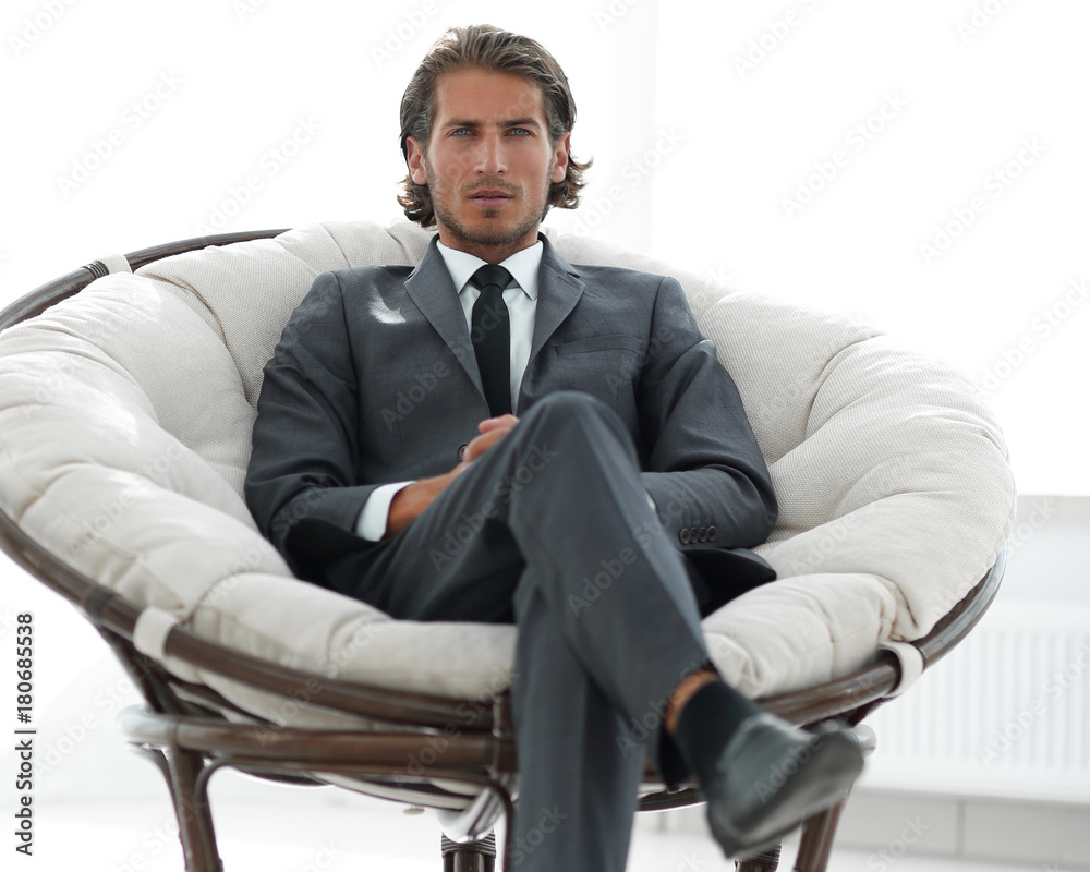 confident businessman sitting in a large comfortable chair. confident businessman sitting in a large comfortable chair.