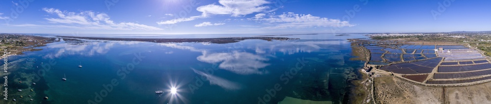 Panoramic aerial cloud seascape, in Ria Formosa wetlands natural park, over Cavacos beach. Algarve.