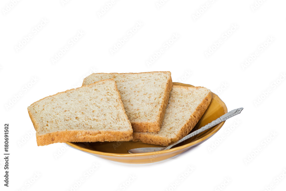 Sliced bread on brown ceramic plate with spoon isolated on white background Sliced bread on brown ceramic plate with spoon isolated on white background