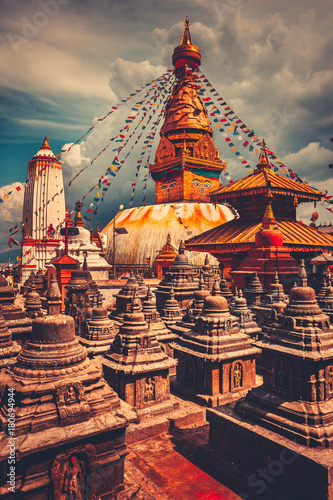 The famous Buddhist stupa at Boudanath in Kathmandu valley, Nepal. Was built in the 14th century. Blue cloudy sky in the background. Travel, holiday. Vintage retro toning filter orange color photo