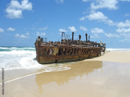 Fényképezés rusty shipwreck on the beach with blue sky