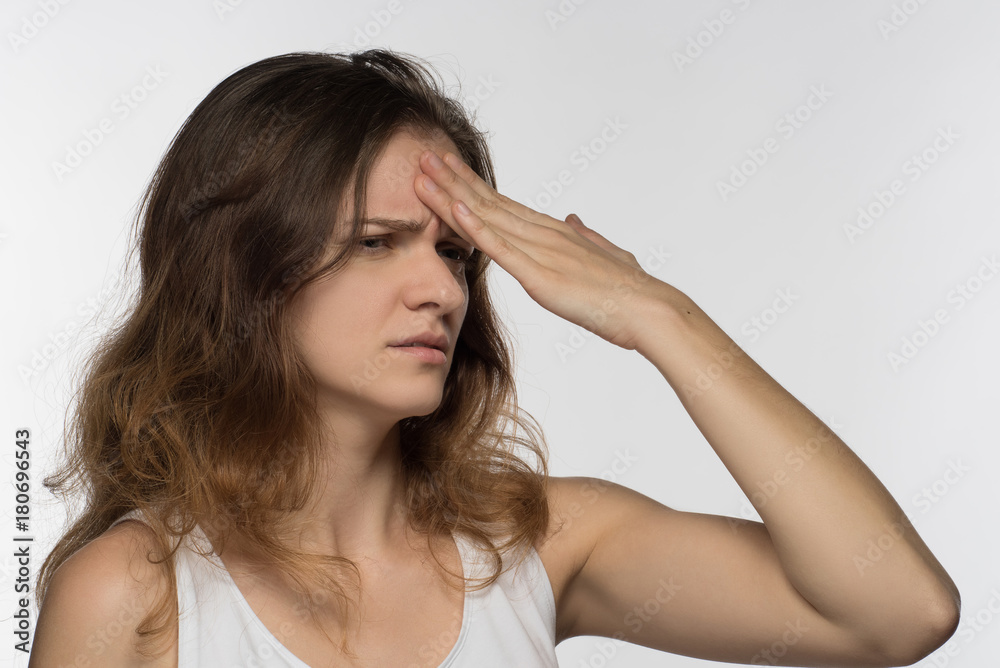 Young girl experiencing headache or depression and mourned over white background Young girl experiencing headache or depression and mourned over white background