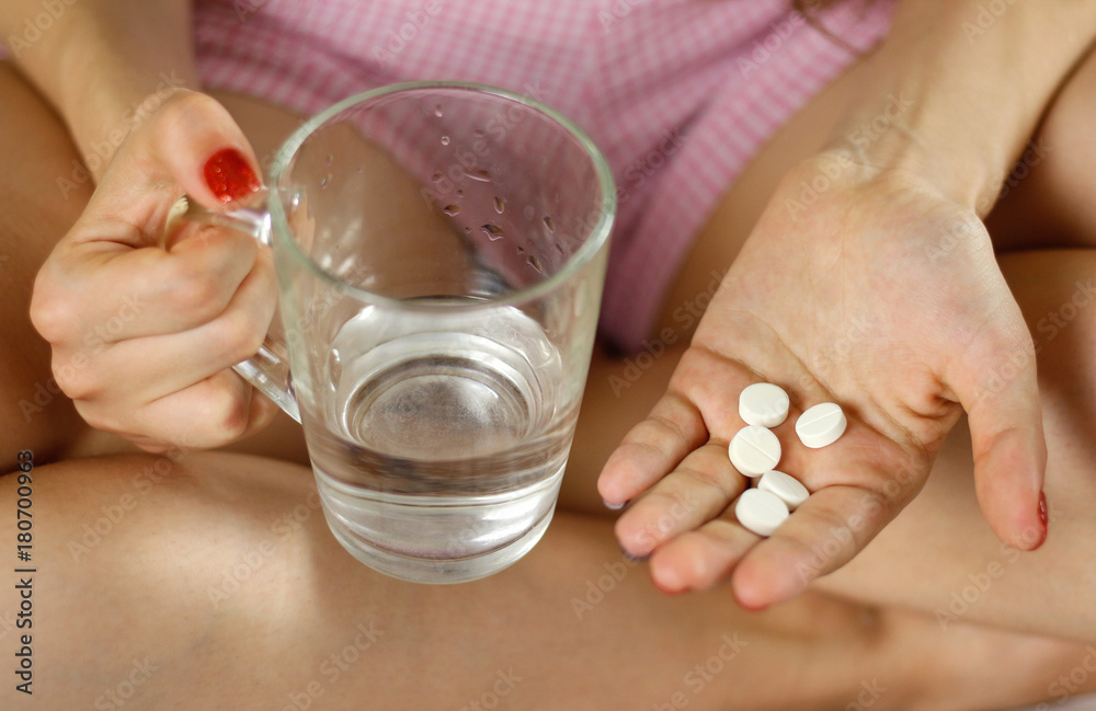 Girl holding a glass of water and pills. Closeup Girl holding a glass of water and pills. Closeup
