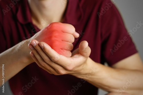 The guy hurts his hand. The pain in his fist. The red fist. Closeup. The lesion is highlighted in red
