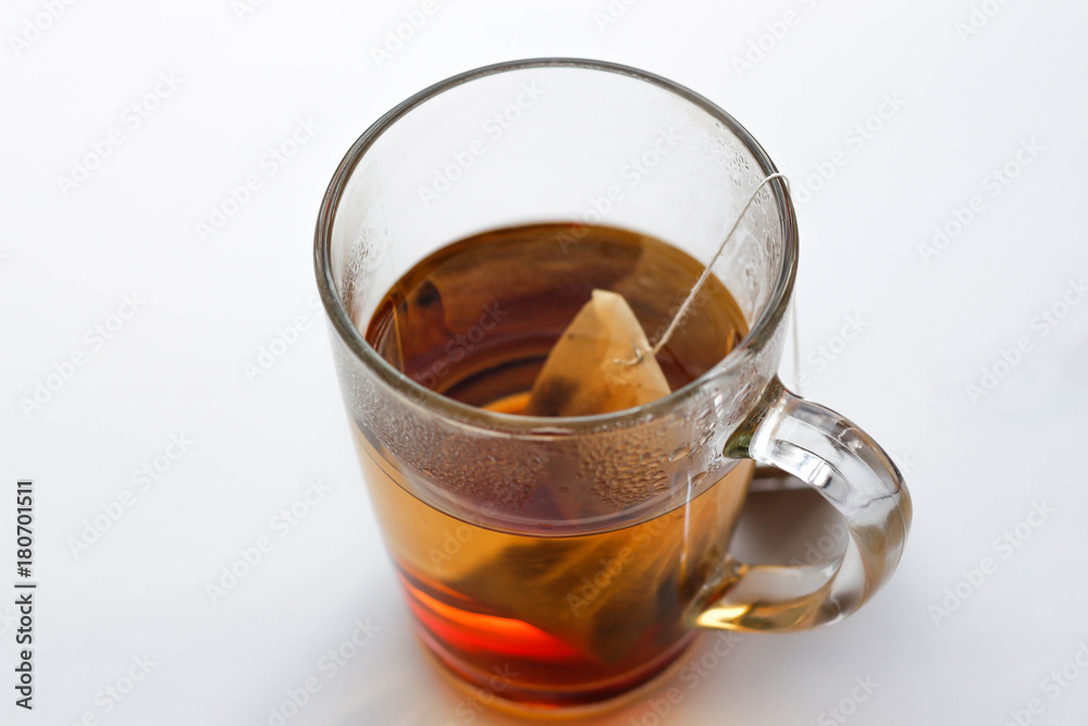 Transparent glass mug and a tea bag. A Cup of tea. Isolated on white background. Closeup