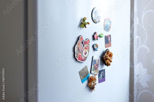 Konstfotografi Different magnets on a white refrigerator in the kitchen. Closeup