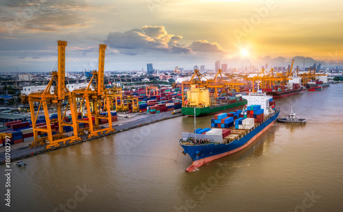 Logistics and transportation of Container Cargo ship and Cargo plane with working crane bridge in shipyard at twilight, logistic import export and transport industry background