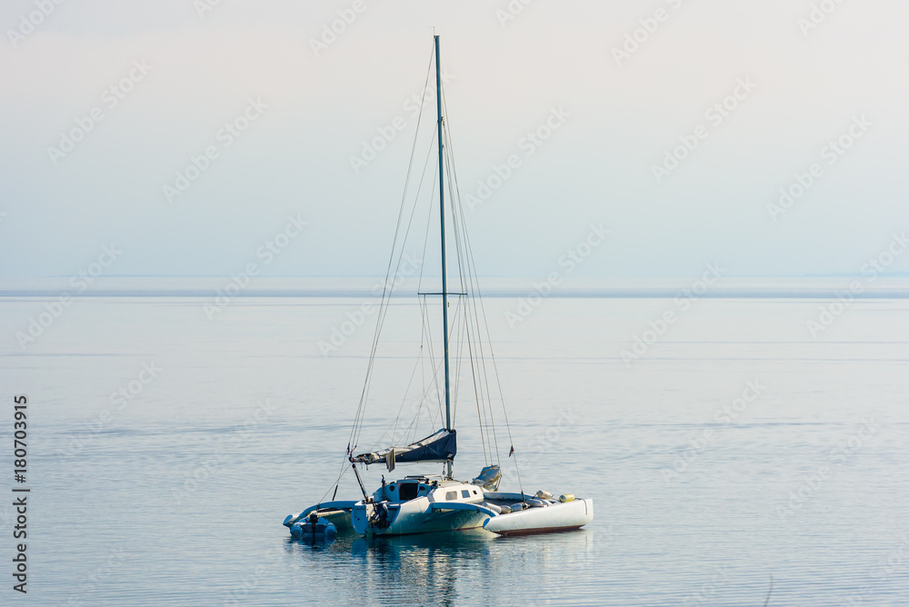 Catamaran is moored in calm sea of Adriatic sea.