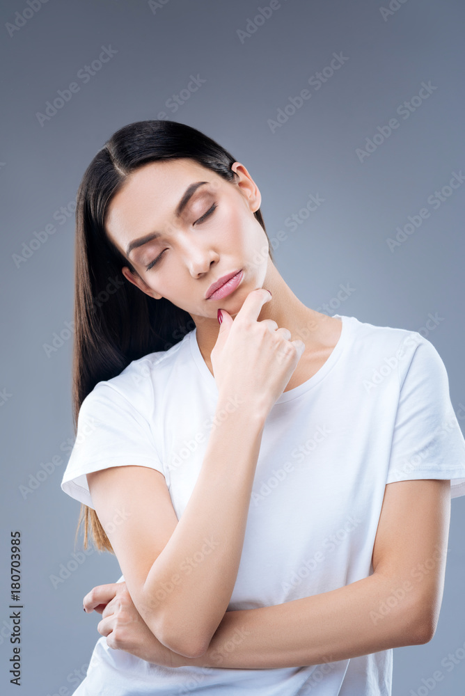 Falling asleep. Young exhausted beautiful woman standing with her eyes closed against the blue background and falling asleep while being at work Falling asleep. Young exhausted beautiful woman standing with her eyes closed against the blue background and falling asleep while being at work