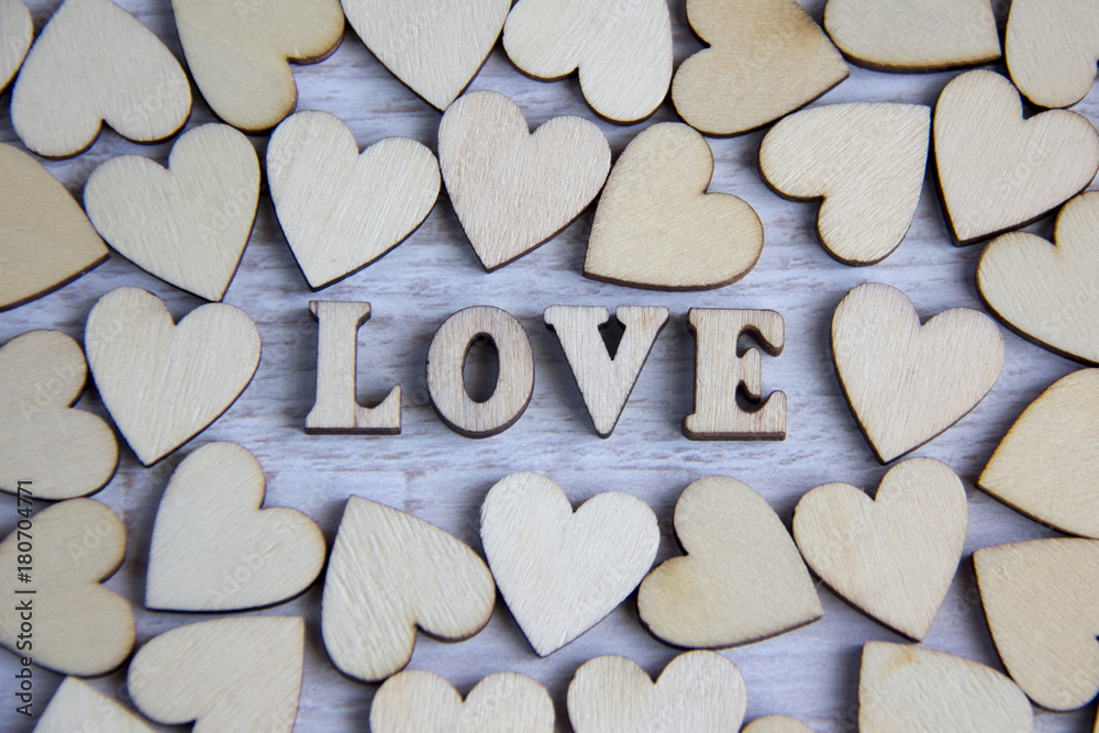 Obraz premium Heart shape from natural tree. Lovely heart shape by wooden small hearts on rustic wood table. Love theme concept with wooden hearts for Valentine's background and love theme.wooden leters i love you.