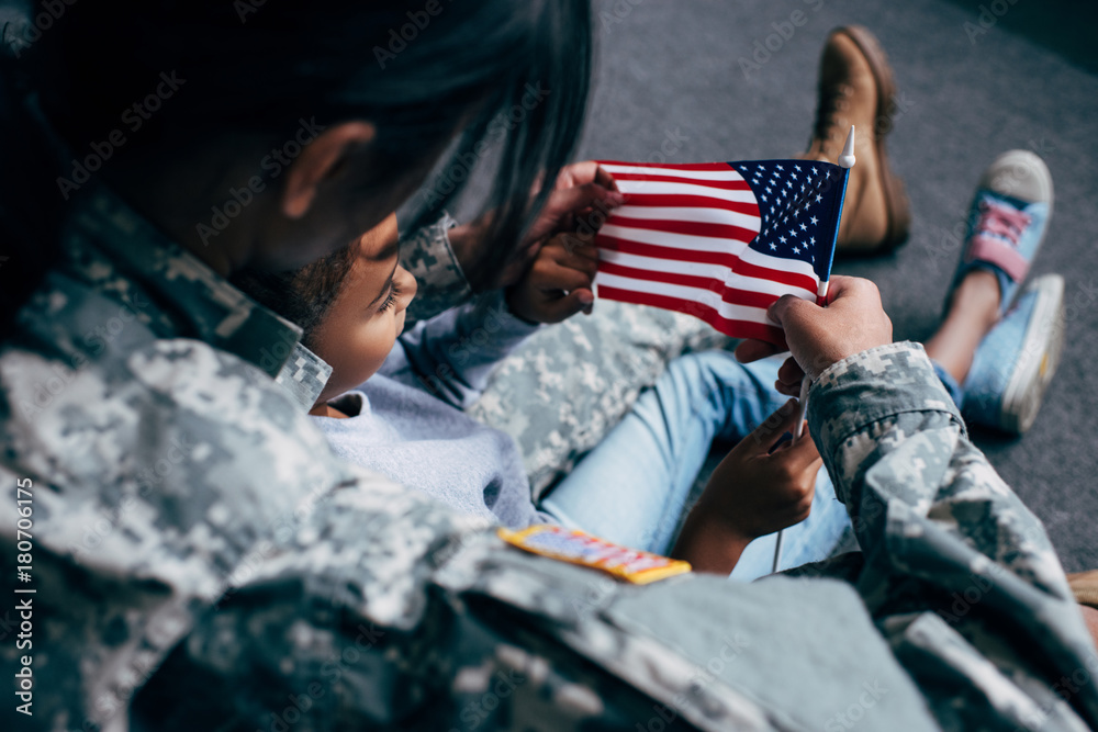 daughter and soldier with american flag