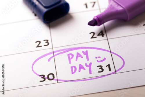 payday concept calendar with marker and circled day of salary photo