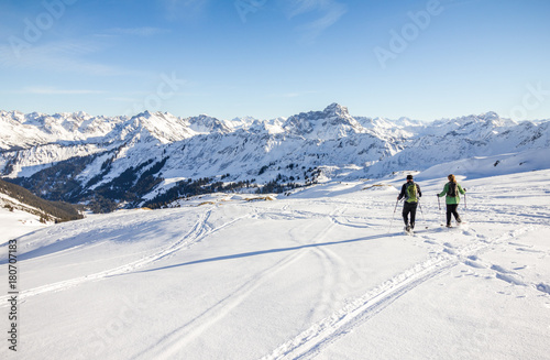 Two snowshoe hikers in alpine winter mountains. Bavaria, Germany.