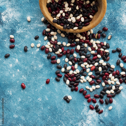 Haricot beans on blue wooden background. Top view. Black, red, white beans.