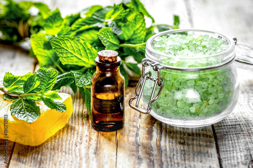organic cosmetics with herbal extracts of mint on wooden backgro