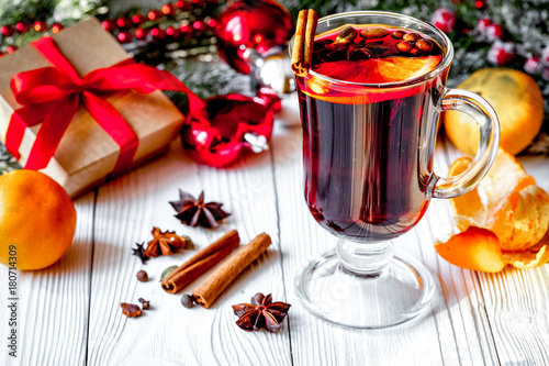 Christmas mulled wine with spices in cup on wooden background